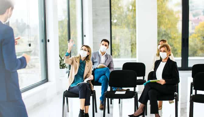 男士在坐着倾听的人群前侃侃而谈。